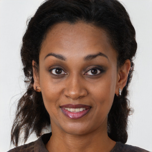 Joyful black young-adult female with long  brown hair and brown eyes