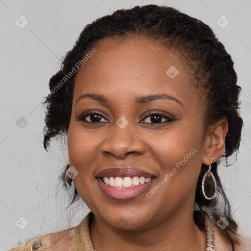 Joyful black young-adult female with long  brown hair and brown eyes