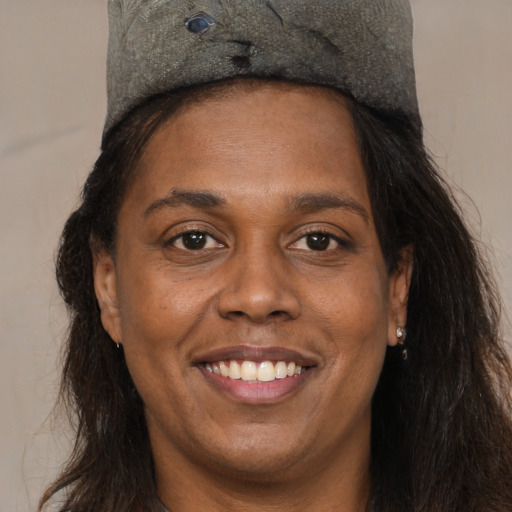 Joyful black adult female with long  brown hair and brown eyes