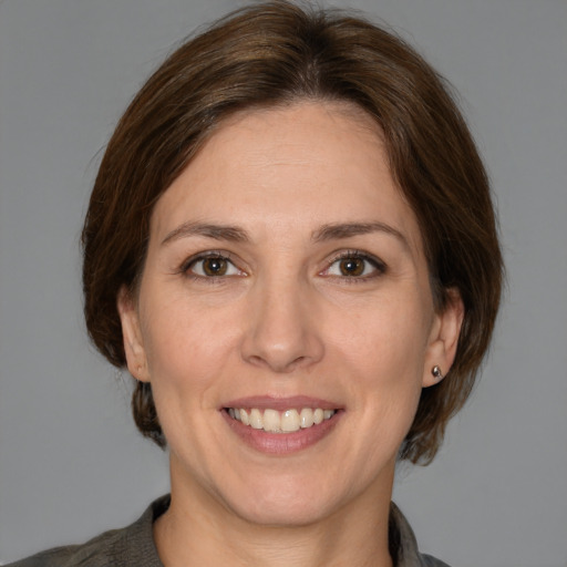 Joyful white adult female with medium  brown hair and brown eyes