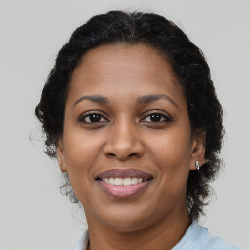 Joyful black young-adult female with medium  brown hair and brown eyes