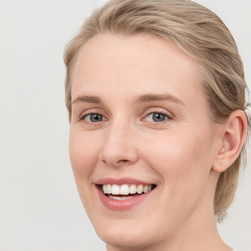 Joyful white young-adult female with medium  brown hair and blue eyes