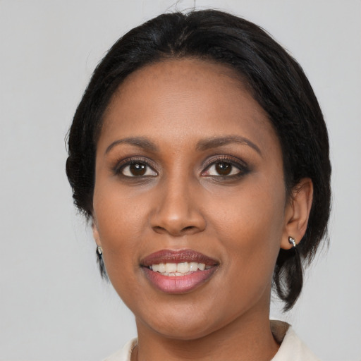 Joyful black young-adult female with medium  black hair and brown eyes
