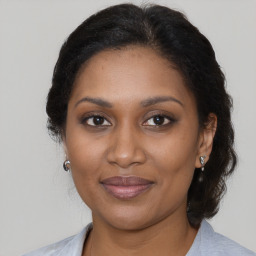 Joyful black adult female with medium  brown hair and brown eyes