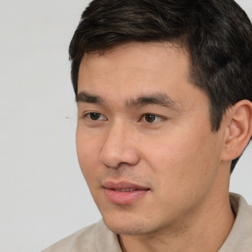 Joyful white young-adult male with short  black hair and brown eyes
