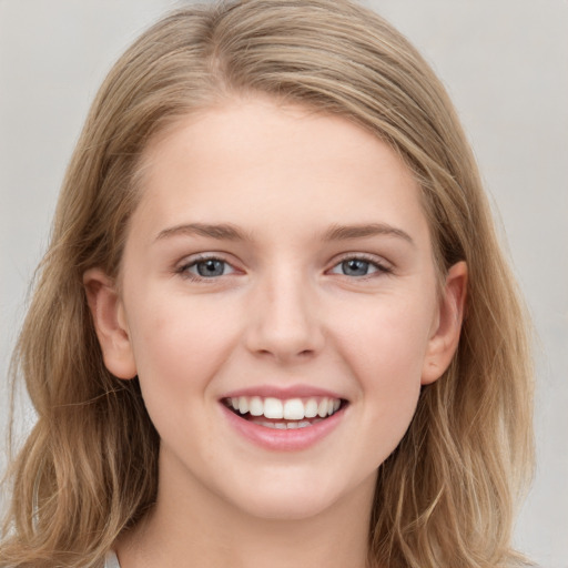 Joyful white young-adult female with long  brown hair and grey eyes