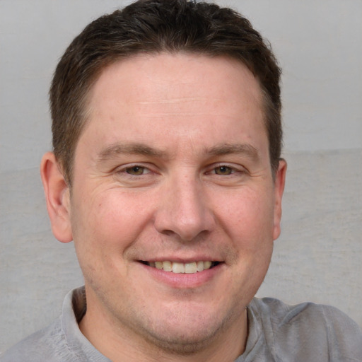 Joyful white adult male with short  brown hair and blue eyes