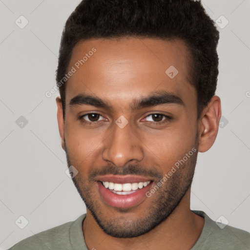 Joyful black young-adult male with short  brown hair and brown eyes