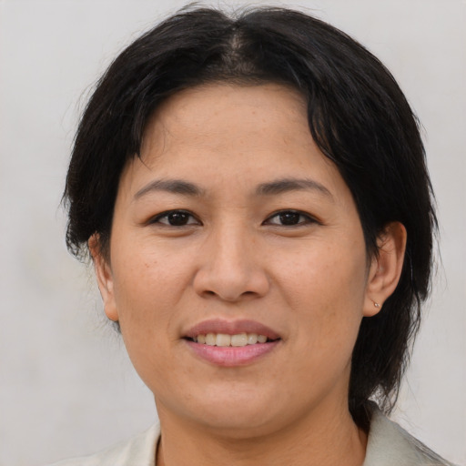 Joyful asian adult female with medium  brown hair and brown eyes
