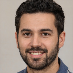 Joyful white young-adult male with short  black hair and brown eyes