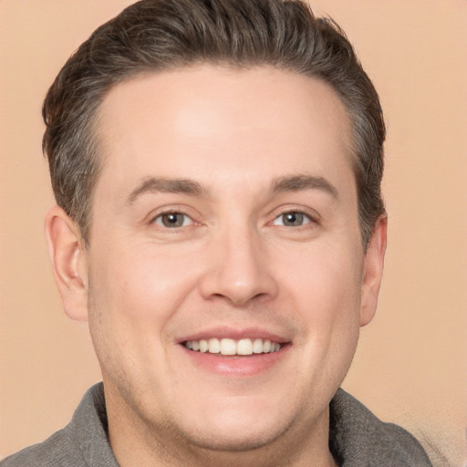 Joyful white adult male with short  brown hair and brown eyes