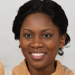 Joyful black young-adult female with long  brown hair and brown eyes