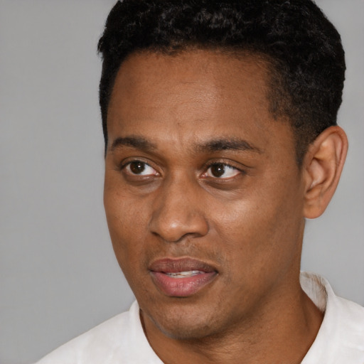 Joyful black young-adult male with short  black hair and brown eyes