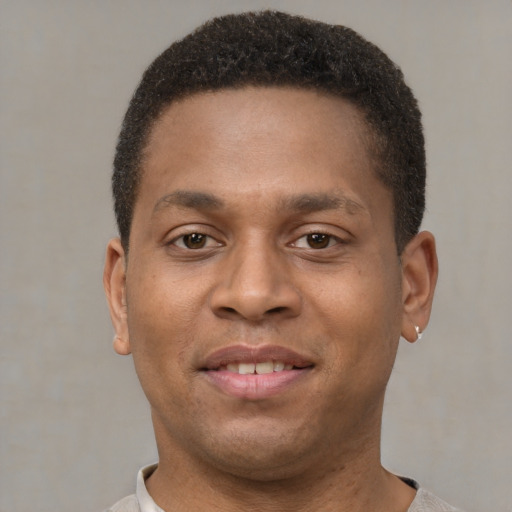 Joyful latino young-adult male with short  brown hair and brown eyes