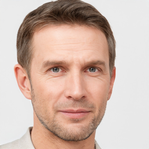 Joyful white adult male with short  brown hair and grey eyes