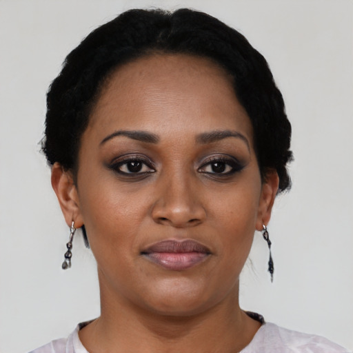 Joyful black young-adult female with short  black hair and brown eyes