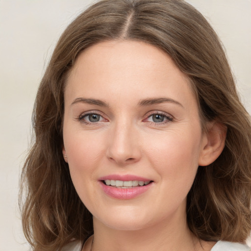 Joyful white young-adult female with medium  brown hair and grey eyes