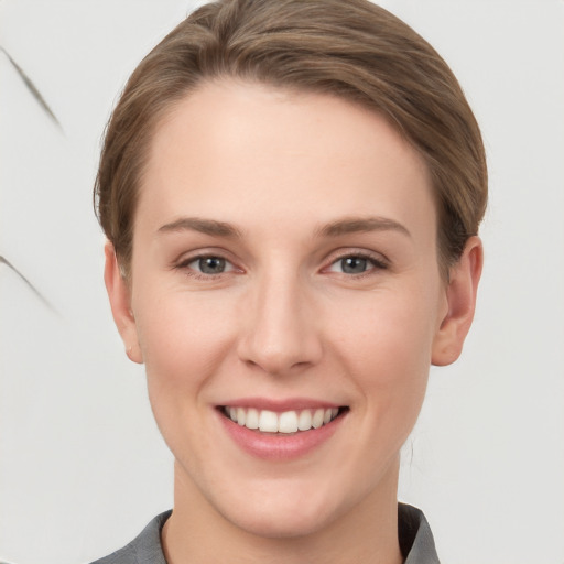 Joyful white young-adult female with short  brown hair and grey eyes