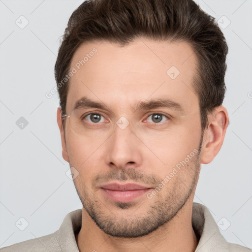 Joyful white young-adult male with short  brown hair and grey eyes