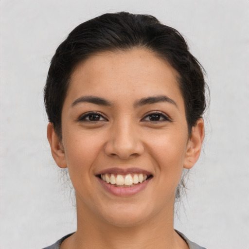 Joyful latino young-adult female with medium  brown hair and brown eyes