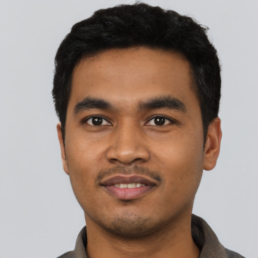 Joyful latino young-adult male with short  black hair and brown eyes
