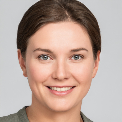 Joyful white young-adult female with short  brown hair and grey eyes