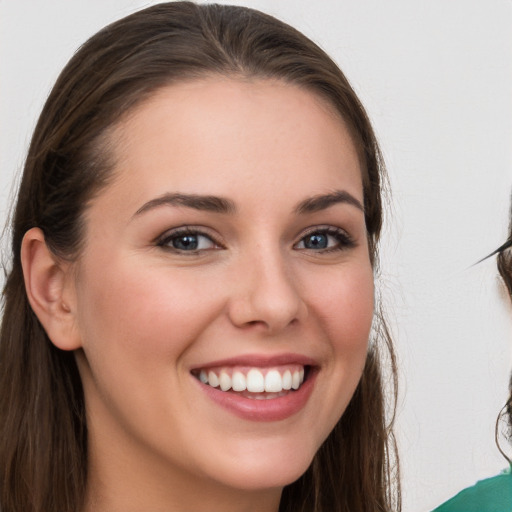 Joyful white young-adult female with long  brown hair and grey eyes