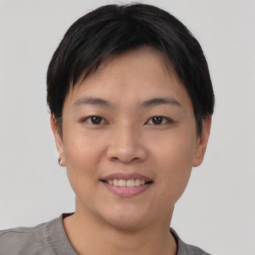 Joyful asian young-adult female with short  black hair and brown eyes