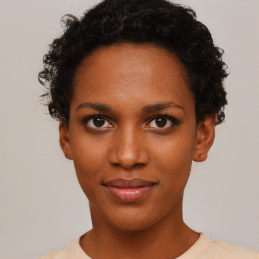 Joyful black young-adult female with short  black hair and brown eyes