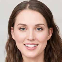 Joyful white young-adult female with long  brown hair and blue eyes