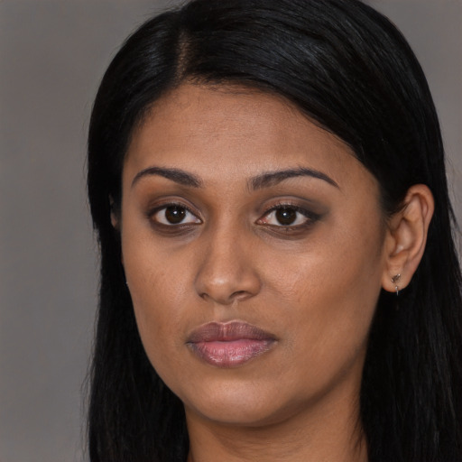 Joyful black young-adult female with long  black hair and brown eyes