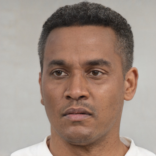 Neutral latino adult male with short  black hair and brown eyes