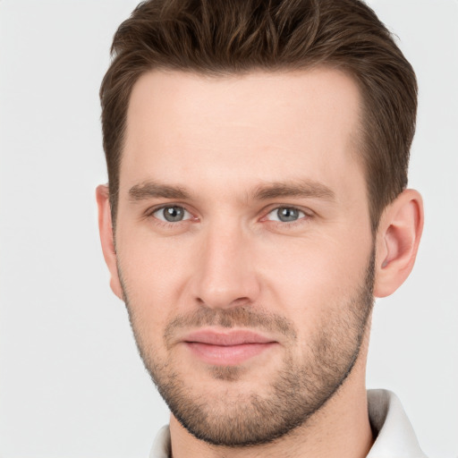 Joyful white young-adult male with short  brown hair and grey eyes