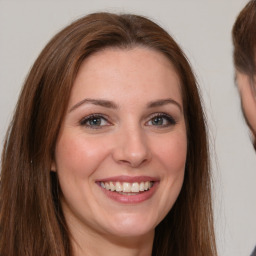 Joyful white young-adult female with long  brown hair and grey eyes