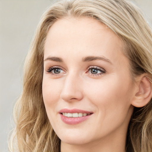 Joyful white young-adult female with long  brown hair and blue eyes