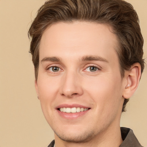 Joyful white young-adult male with short  brown hair and grey eyes