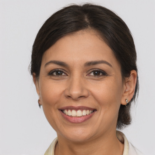 Joyful latino adult female with medium  brown hair and brown eyes