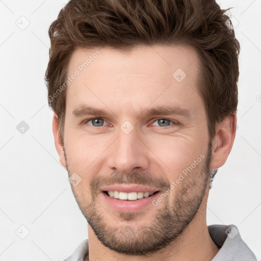 Joyful white young-adult male with short  brown hair and grey eyes