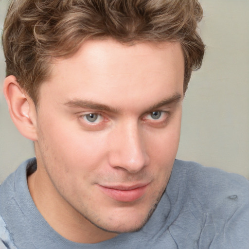 Joyful white young-adult male with short  brown hair and blue eyes