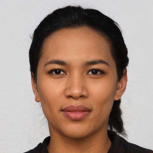 Joyful latino young-adult female with short  black hair and brown eyes