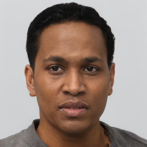 Joyful black young-adult male with short  black hair and brown eyes
