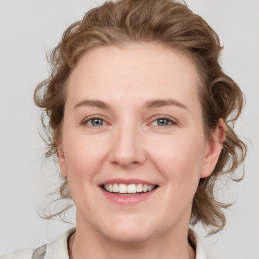 Joyful white young-adult female with medium  brown hair and blue eyes