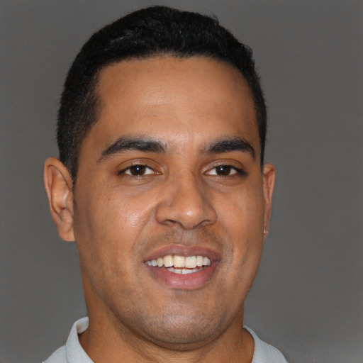 Joyful black young-adult male with short  brown hair and brown eyes
