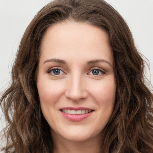 Joyful white young-adult female with long  brown hair and green eyes