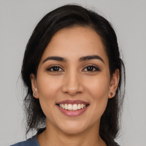 Joyful latino young-adult female with long  brown hair and brown eyes