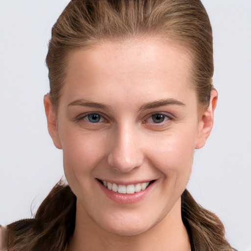 Joyful white young-adult female with long  brown hair and grey eyes