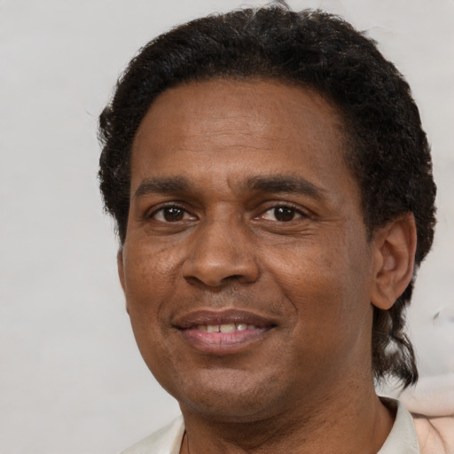 Joyful black adult male with short  brown hair and brown eyes