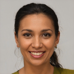 Joyful latino young-adult female with medium  brown hair and brown eyes