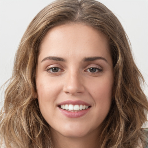 Joyful white young-adult female with long  brown hair and green eyes