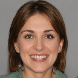 Joyful white young-adult female with medium  brown hair and blue eyes